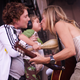 Sheryl Crow kisses her son Wyatt as she performs at the 2010 Lilith Fair.